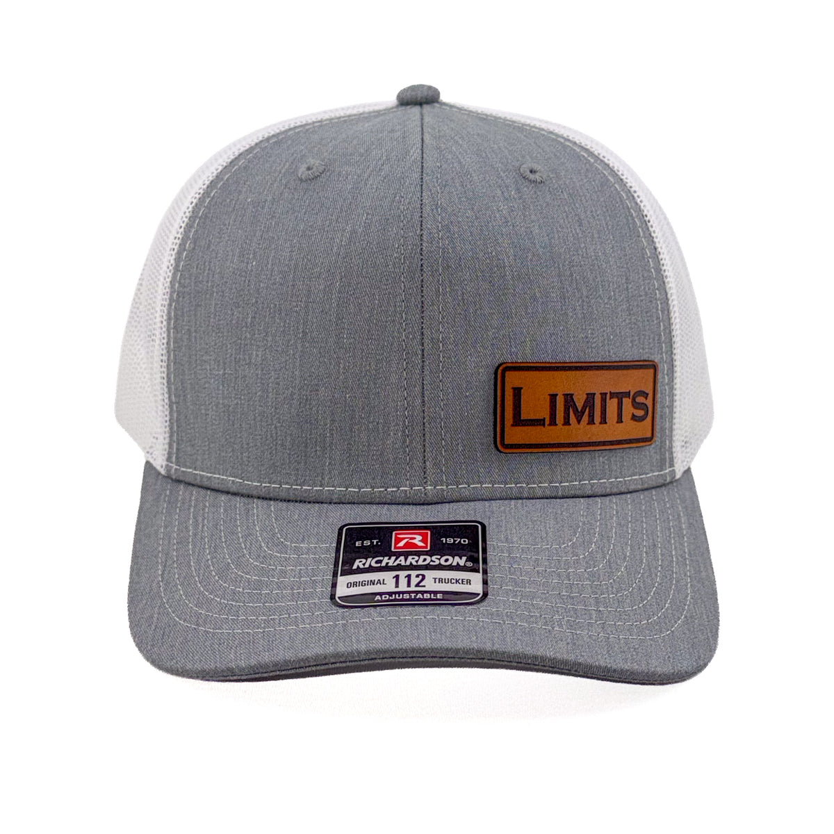 A Richardson 112 trucker hat in heather grey and white mesh, featuring a brown leather patch on the front with the word 'LIMITS' and a Richardson brand sticker on the visor.