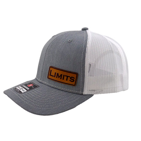 A Richardson 112 trucker hat in heather grey and white mesh, featuring a brown leather patch on the front with the word 'LIMITS' and a Richardson brand sticker on the visor.