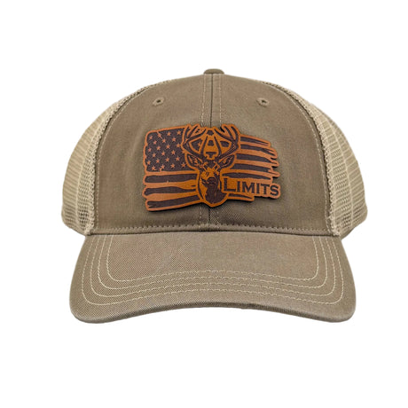A tan trucker hat with a brown embroidered patch on the front featuring a deer head over an American flag and the text 'DEER LIMITS'. The hat has a tan canvas front and visor, with beige mesh back panels.
